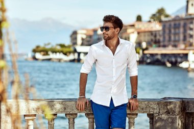 Portrait of handsome man wearing elegant white shirt and sunglas