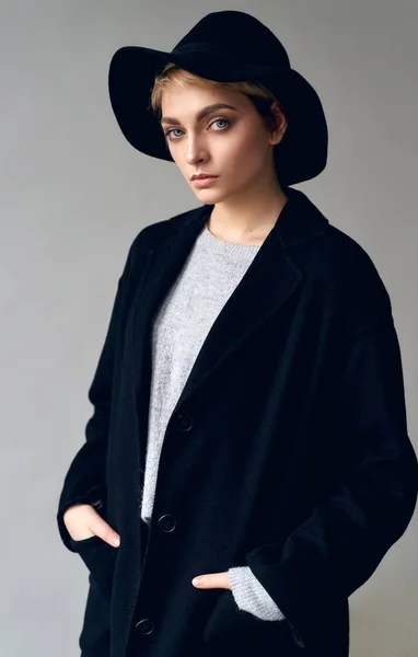 セクシー女性で黒スタイリッシュな衣装上の灰色の背景 — ストック写真
