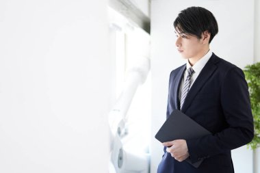 Bir Japon işadamı yüzünde ciddi bir ifadeyle pencereden dışarı bakar.