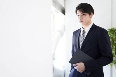 Japon bir işadamı kameraya ciddi bir ifadeyle bakıyor..