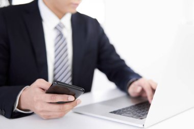 Japon bir erkek işadamı akıllı telefonundan veri topluyor.