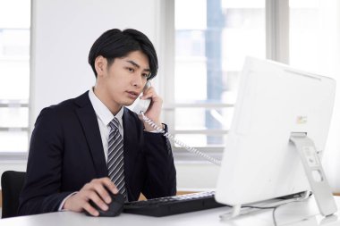 Japon bir erkek işadamı telefona cevap veriyor..