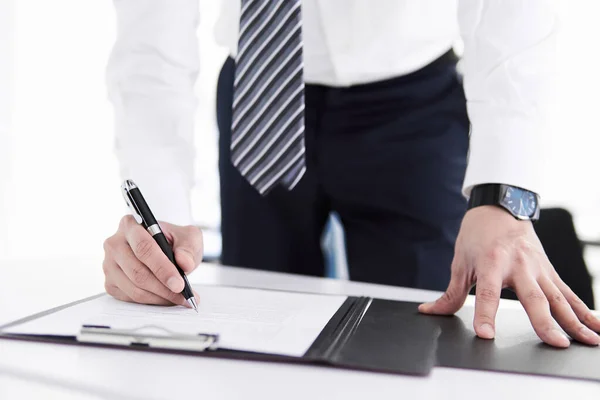 Japanese male businessman on hand to sign papers