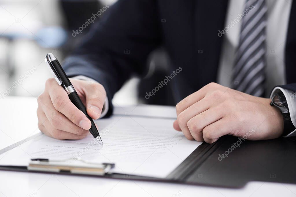 Japanese male businessman on hand to sign papers