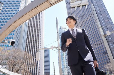 Cesur bir Japon işadamı ofis bölgesinde yürüyor..