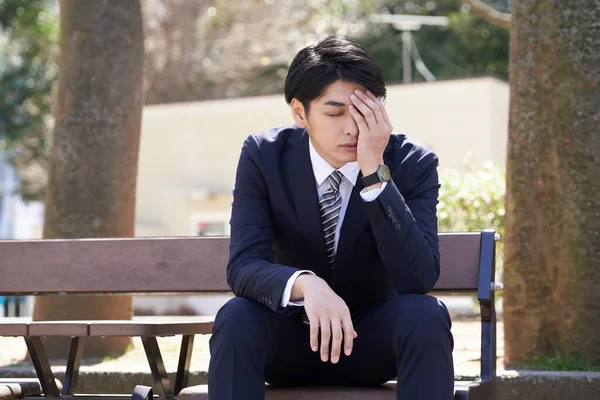 Japanese male businessmen who are troubled by worries