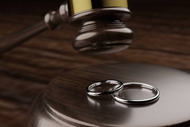 Evlilik yüzükleri ve çekiçler boşanma sorunları imajında.