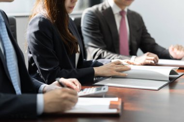 Japon bir işadamı, aydınlık bir konferans odasında toplantı yapıyor..