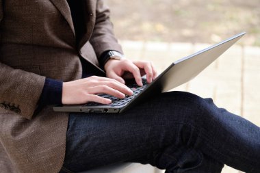 Dışarıda bilgisayar kullanan ceketli bir Japon..