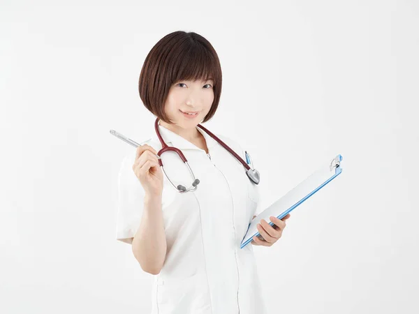 Japansk Kvindelig Sygeplejerske Forklarer Sine Point Med Smil Hvid Baggrund - Stock-foto