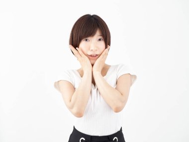 Elleri yanaklarında ve beyaz arka planda şaşırmış bir kadın.