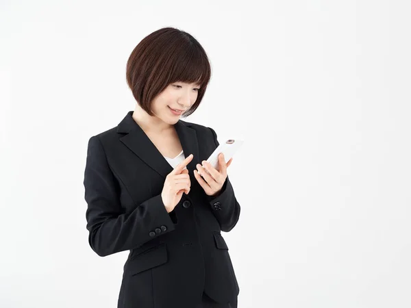Японская Офисная Работница Проверяет Смартфон Улыбкой Белом Фоне — стоковое фото