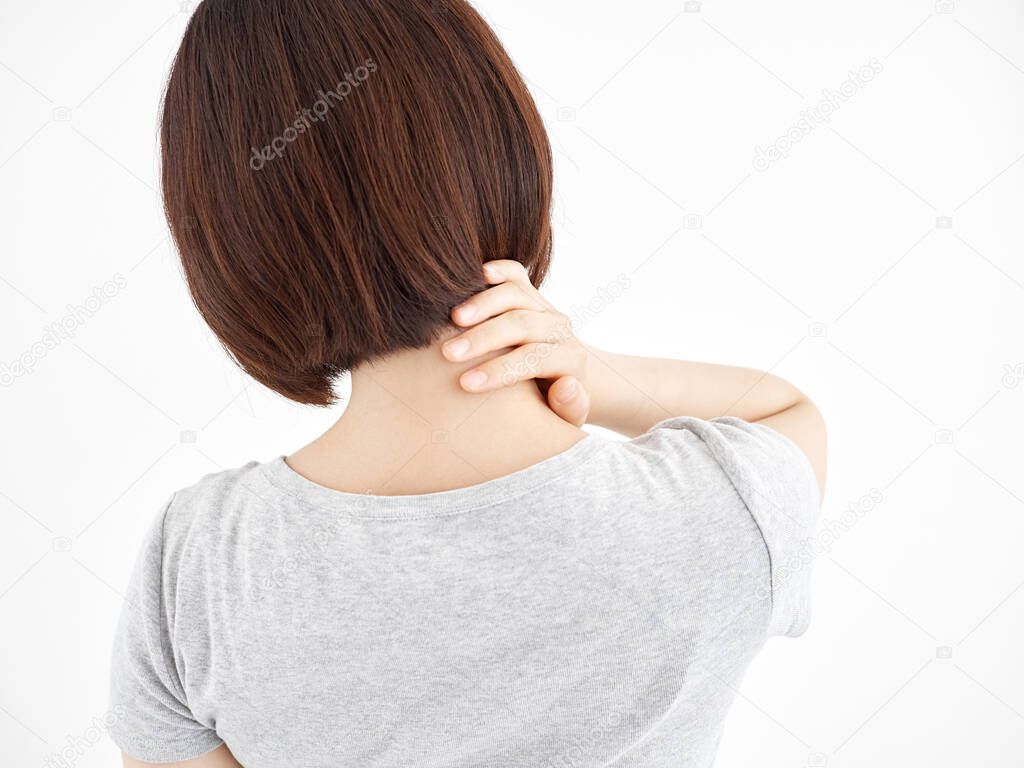A woman holding a sore shoulder against a white background