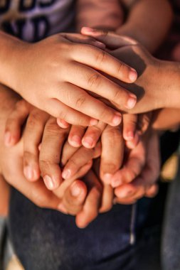 Close up join hands of a family member. A father, mother, daughter and son.
