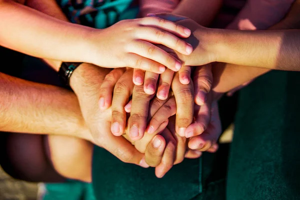 Close up join hands of a family member. A father, mother, daughter and son.