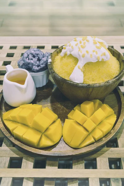 Bingsu ya da hindistancevizli taze krema ve mango dilimlenmiş Kore usulü tatlı pilav ve mango sosuyla servis edilmiş buzlu tatlı..