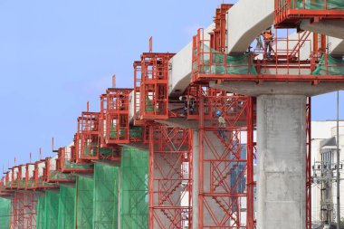 İşçiler Gök Demiryolunun Beton Kirişleri için Hizalama Aletleri Kuruyor