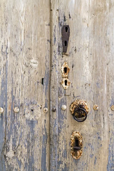 Golpeador oxidado y cerraduras en una puerta de madera muy vieja — Foto de Stock