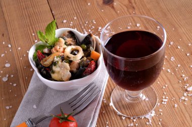 Balık soslu kase ve kırmızı şarap.