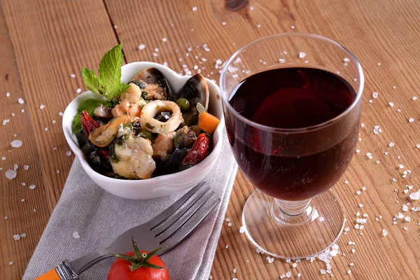 Balık soslu kase ve kırmızı şarap.