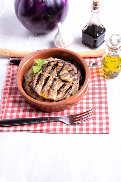 Terracotta bowl with roasted aubergines flavored with vinegar an