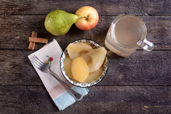 Tigela com maçãs cozidas e peras e jarro de xarope — Fotografia de Stock