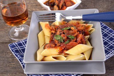 Masadaki tabakta midye soslu Pennoni makarna.