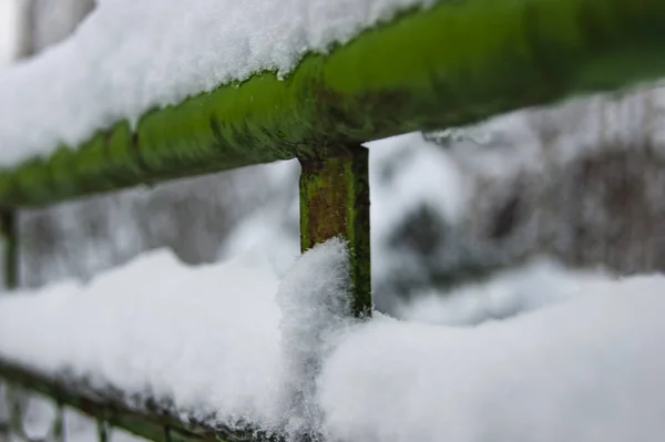 Élément recouvert de neige de la vieille clôture. L'hiver passa et la neige resta . — Photo
