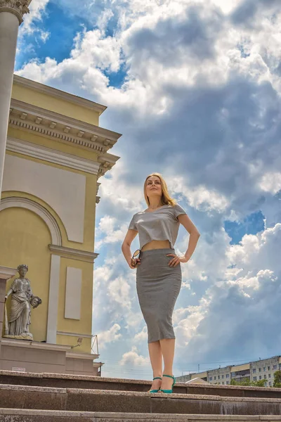 Gri elbiseli bir kız yaz şehrin içinden yürüyor