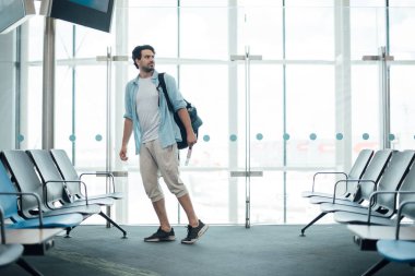 Havaalanında sırt çantası olan adam.