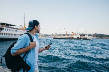 Denizin arka planına karşı genç bir adamın portresi, şehir,
