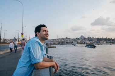 Köprüde genç bir adam şehrin uzaklığına bakıyor.. 