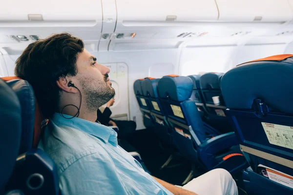 Парень летит на самолёте, слушает музыку. . — стоковое фото