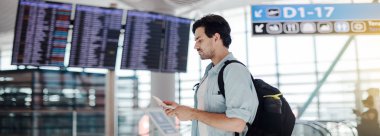 Havaalanında kalkış bekleyen adam, program aranıyor. 