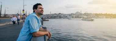 Köprüde genç bir adam şehrin uzaklığına bakıyor.. 