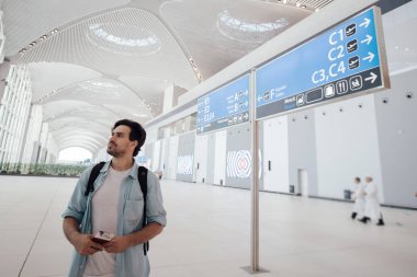 Havaalanında kalkış bekleyen adam, program aranıyor. 