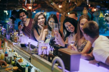 Arkadaşlar yeni yılı barın arkasındaki barda kutluyor..