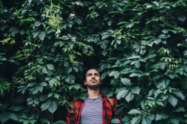 Yeşil yapraklı genç bir adamın portresi