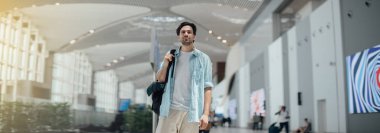 Havaalanında sırt çantası olan adam.