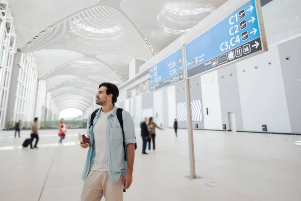 The guy at the airport waiting for departure, looking schedule. — Stock Photo, Image