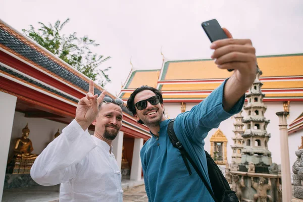 Мужчины в буддийском храме делают селфи по телефону . — стоковое фото