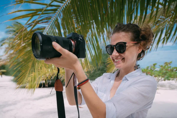 Chica fotógrafa, videógrafa con una cámara profesional en los trópicos . — Foto de Stock