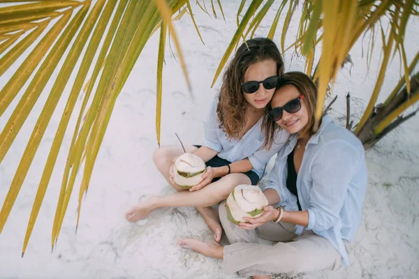 Para kochanków dziewczyny z koktajlami na tropikalnej plaży. — Zdjęcie stockowe