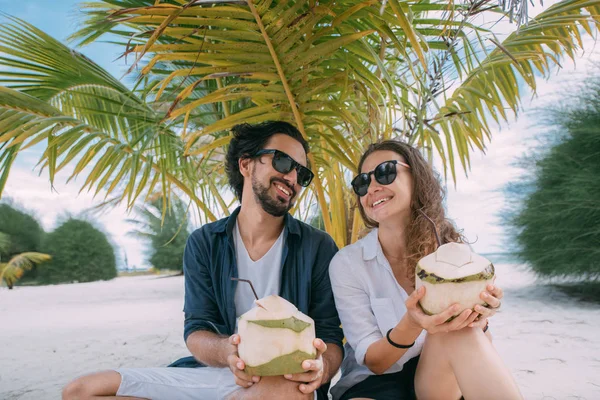 Boldog szerelmespár koktélokkal a trópusi tengerparton. — Stock Fotó