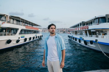 Denizin arka planına karşı genç bir adamın portresi, şehir,