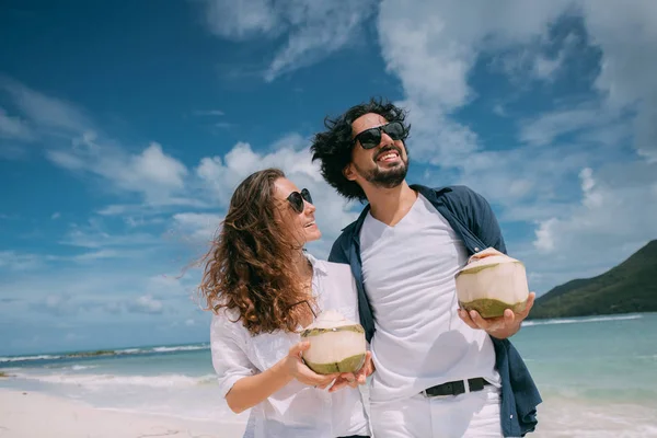 Gelukkige paren met cocktails op een tropisch strand. — Stockfoto