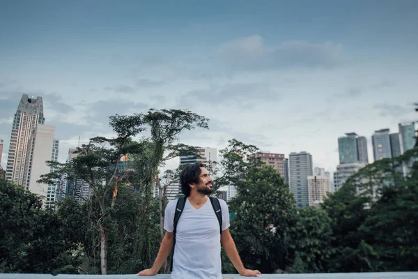 Um homem admira a vista contra o pano de fundo dos arranha-céus — Fotografia de Stock