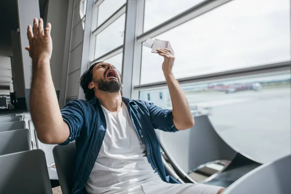 O homem está muito chateado na sala de espera no portão para o aeroporto — Fotografia de Stock