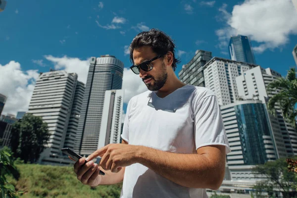 Un hombre habla por teléfono con el telón de fondo de los rascacielos —  Fotos de Stock