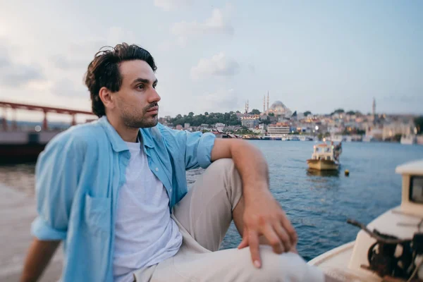 Retrato de un joven sobre el fondo del mar, la ciudad, el muelle y los barcos —  Fotos de Stock